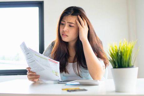 An image of woman looking at her documents trying to figure out which is the best bank account if you have bad credit.