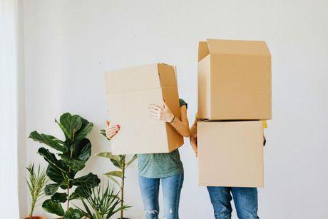 A couple holding their boxes of stuff after moving in to a new 100% mortgage deal.