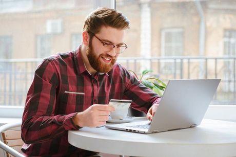 A man in front of his laptop searching information about how do credit builder prepaid cards work.