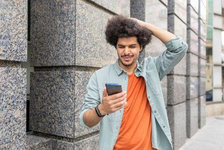 An image of a confused young man looking at his phone wondering about a unknown soft check.