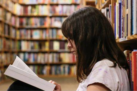 An image of young woman reading a book about Consumer Credit Act in a library.