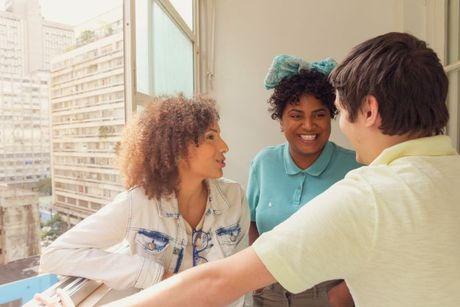 A woman explaining on her two friends about how do joint mortgages work in the UK.