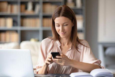 A woman in front of her laptop searching on the internet if Experian is free.