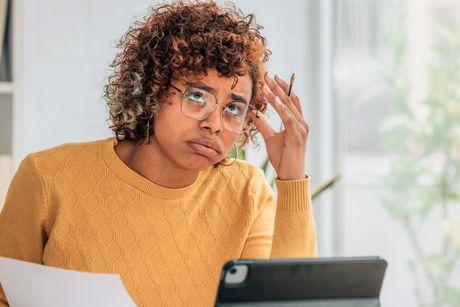 A young woman looking very tired waiting for the mortgage pre-approval