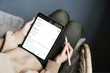 An image of a woman holding her tablet showing a ClearScore page on the screen.