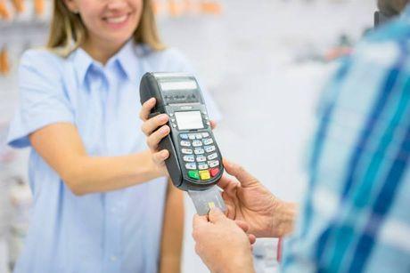 An image of someone paying stuff with an NFC machine and a debit card an getting into an overdraft.