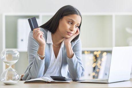 A young woman looking confuse in front of her laptop trying to figure out how balance transfer cards help her with a bad credit.