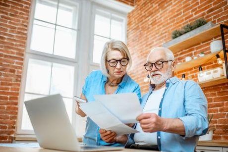 An old couple looking at their documents to see debt from their credit report.