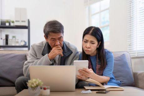 Middle-aged couple in front of laptop researching UK credit repair companies