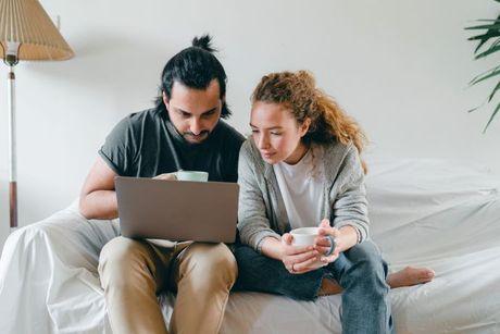 A couple looking at a laptop and some documents, trying to figure out on how to check Experian credit report for free.