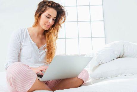 A woman at her home sitting in front of his laptop searching about How the Experian credit score works in the UK.