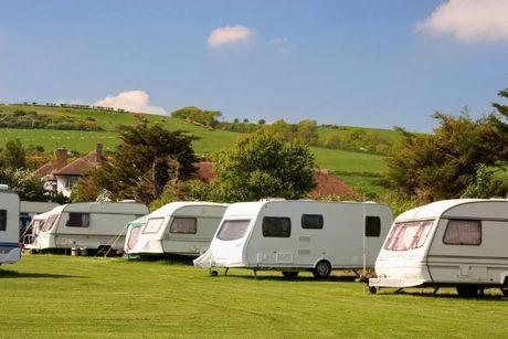 An image of multiple Caravan in a big green open space.