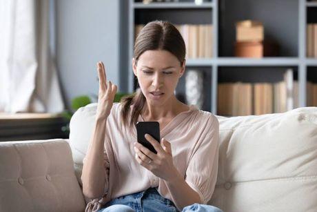 A woman looking at her phone searching about What is the Credit Karma credit score range in the UK.