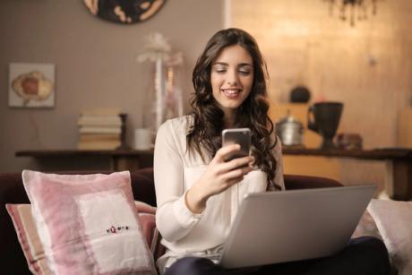 Young woman looking at her phone searching for ways to improve her credit score.