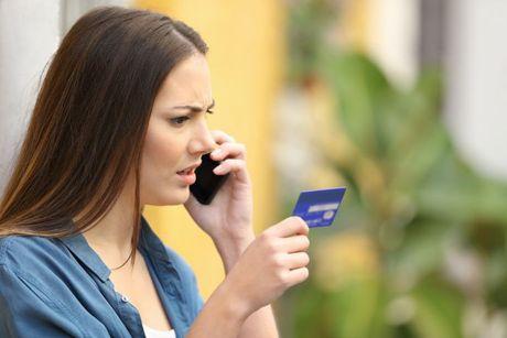 A young woman calling a customer service after her credit card being closed due to inactivity and wondering if it will affect a credit score.