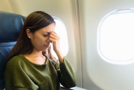 A young woman inside an airplane feeling stressed thinking about her eligibility for Fly Now Pay Later.