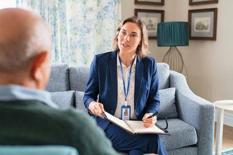 An old man with a lenders explaining to him about doorstep loans.