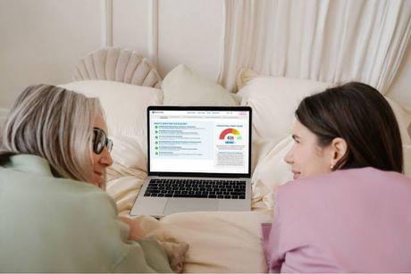 A woman with her friend in front of her laptop searching and talking about what is CheckMyFile.