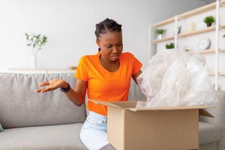 A young woman opening her package after using Laybuy 'buy now pay later' (BNPL) service.