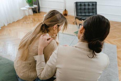 A woman and her friend looking at her laptop trying to figure out what does being a guarantor involve.