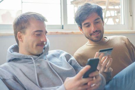 Two young men comparing credit builder cards and loans offers.