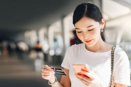 A picture of a girl looking at her credit card and her phone to search if credit cards affect a credit score