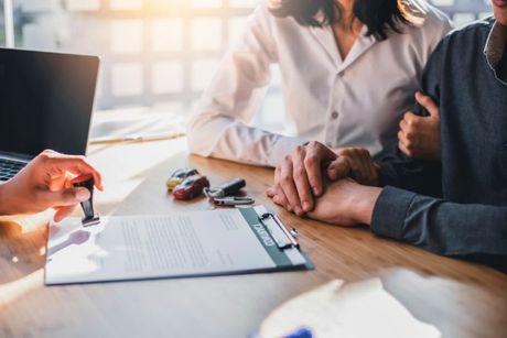 An image of a couple signing a mortgage in a Barclays office.