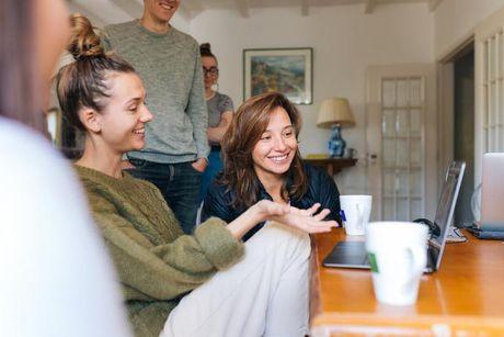 A woman explaining to her friends about how to improve a credit score in the UK.