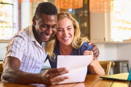 A happy couple looking at a decision in principle document.