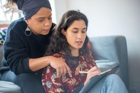 A woman teaching her friend about how to build a credit without a credit card.