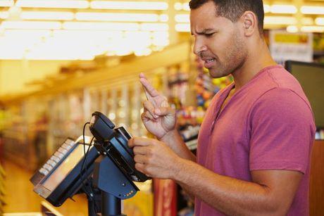 An image of a man using his card to pay and getting into overdraft.