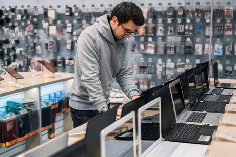 A young man inside an electronics store looking to buy a laptop on finance.