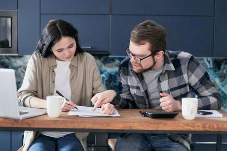 A couple reading a document and trying to get a mortgage in principle with bad credit