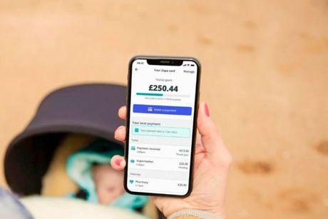 An image of someone holding a phone showing Zopa credit card app on the screen.
