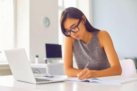 An image of young woman in front of her laptop adding a notice of correction with TransUnion.