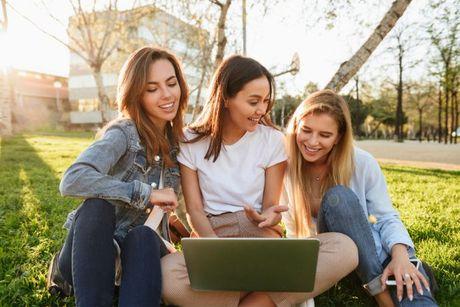 3 friends in front of a laptop discussing how to get a joint mortgage with 3 applicants