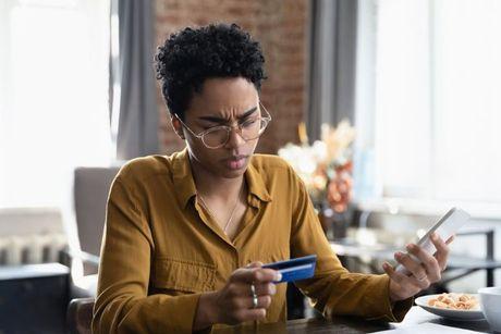 A young woman looking at his Vanquis credit builder card 