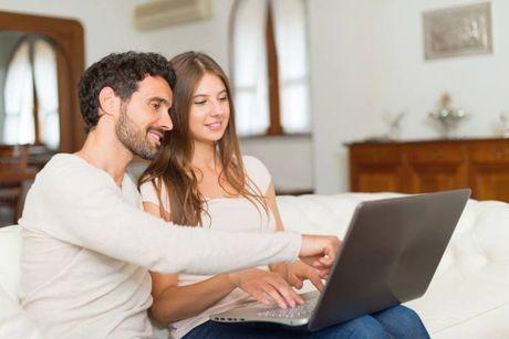 A man showing to his partner in front of her laptop about which is the best credit score website in the UK.