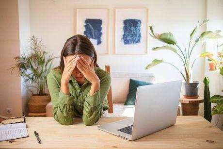 A woman sitting at her home in front of her laptop and feeling annoyed that she can't login to her Experian account.