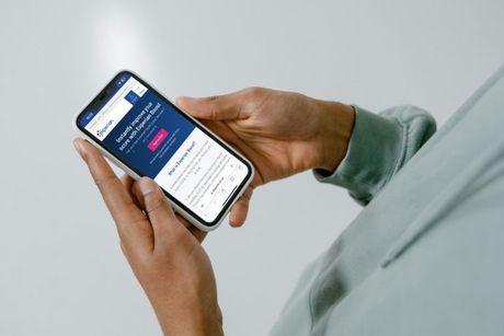 An image of someone holding a phone showing Experian Boost page on the screen.