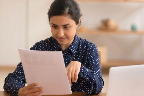 A girl looking at her documents, and trying to figure out how to check her mortgage affordability.