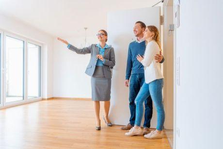 A young couple viewing a rental flat and discussing paying a holding deposit.