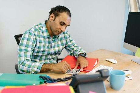 A guy calculating his credit score on his office desk