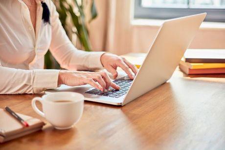 An image of young woman in front of her laptop adding a notice of correction with Experian.