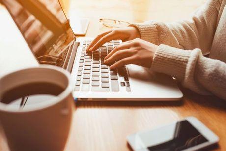 An image of young woman in front of her laptop adding a notice of correction with Equifax.