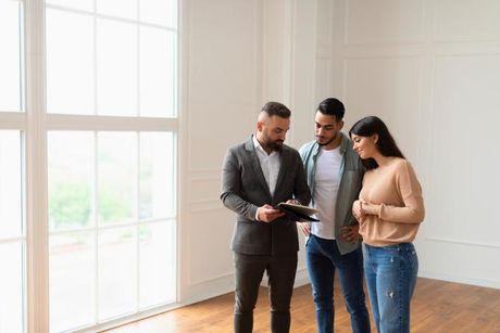 A couple buying a home for the first time and talking to their mortgage broker to ask about the first time homebuyer credit score requirements.