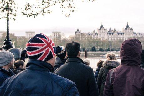 A group of people outside, one of whom is wearing a beanie with the UK flag.