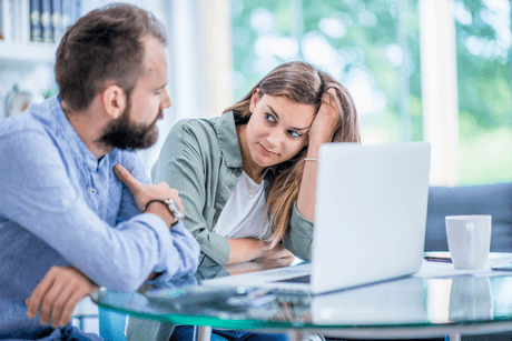 A woman and her friend in front of her laptop searching and discussing if Experian is accurate.