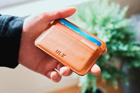 An image of someone holding a wallet with multiple credit cards in it.