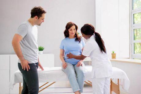 A couple going to a doctor to check the wife's belly for an ultrasound.